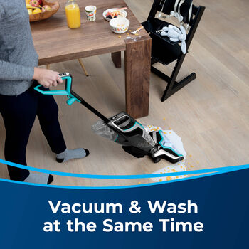 CrossWave Cordless Cleaning Wet Mess off hard flooring in dining area. Text: Vacuum &amp; Wash at the Same Time